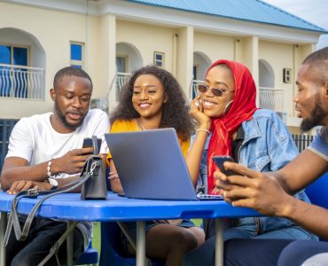 A group of young African people hanging out in an outdoor cafe