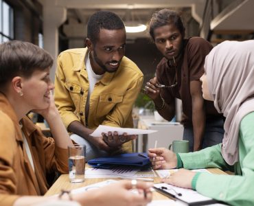 medium-shot-colleagues-discussing-table