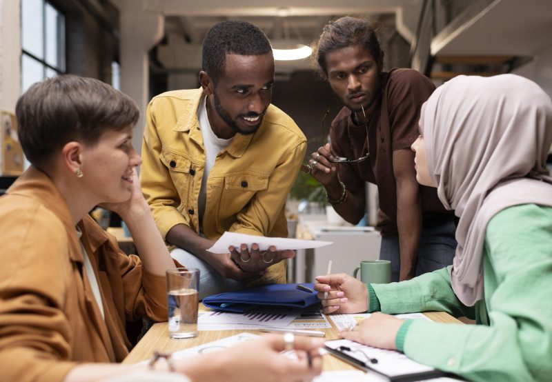 medium-shot-colleagues-discussing-table